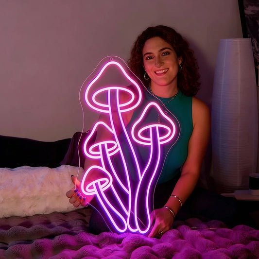Woman holding a neon mushroom sign in a dimly lit room