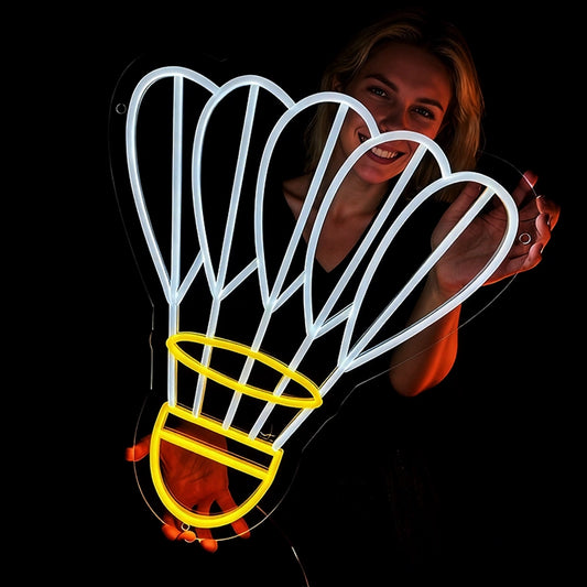 Person holding a neon shuttlecock light with lemon yellow and white color in a dark background