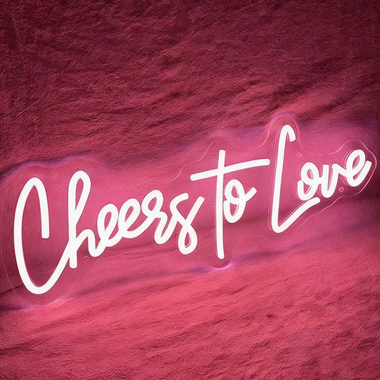 Neon light pink sign with 'Cheers to Love' on a textured dark background