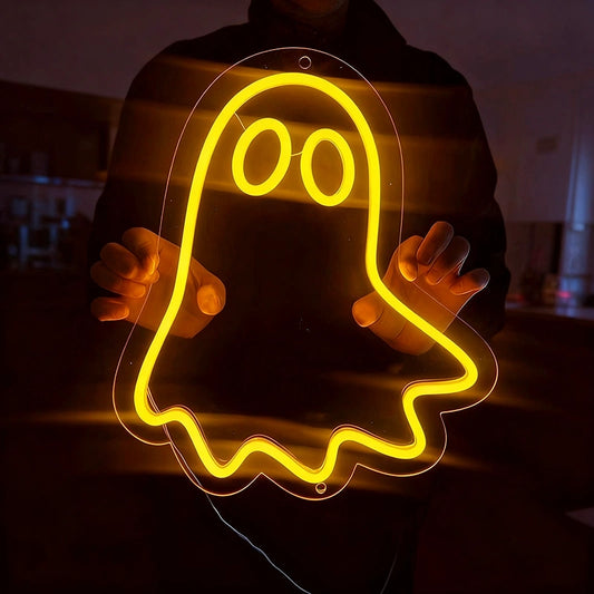 Person holding a lemon yellow neon ghost sign in a dark living room