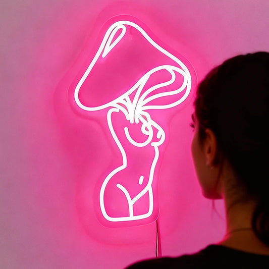 Person looking at a pink neon sign of a woman's silhouette on a dark background