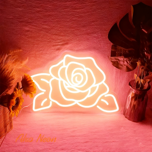 Neon rose warm white light on a pink background with decorative plants.