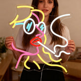 Person holding a colorful neon sign shaped like a person