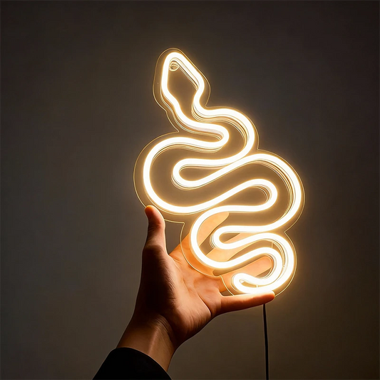 Neon warm white light shaped like a snake held in a hand against a dark background