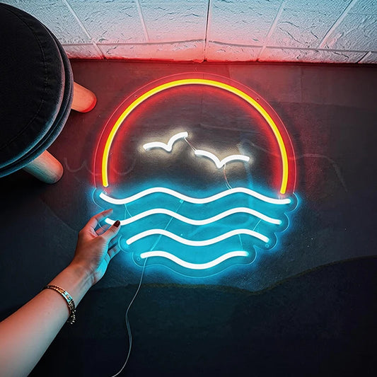 Neon sign with orange, white, and ice blue lights on a dark surface.