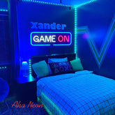 Neon-lit bedroom with 'Xander Game On' sign and gaming-themed decor.