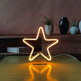 Star-shaped neon light on a wooden surface with a blurred background