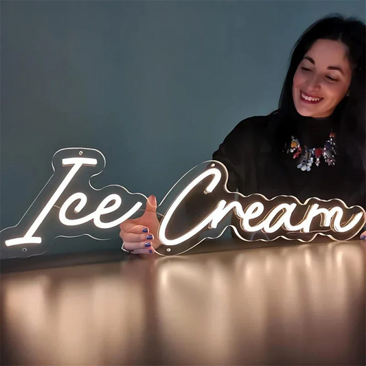Woman standing behind a neon 'Ice Cream' sign on a dark background