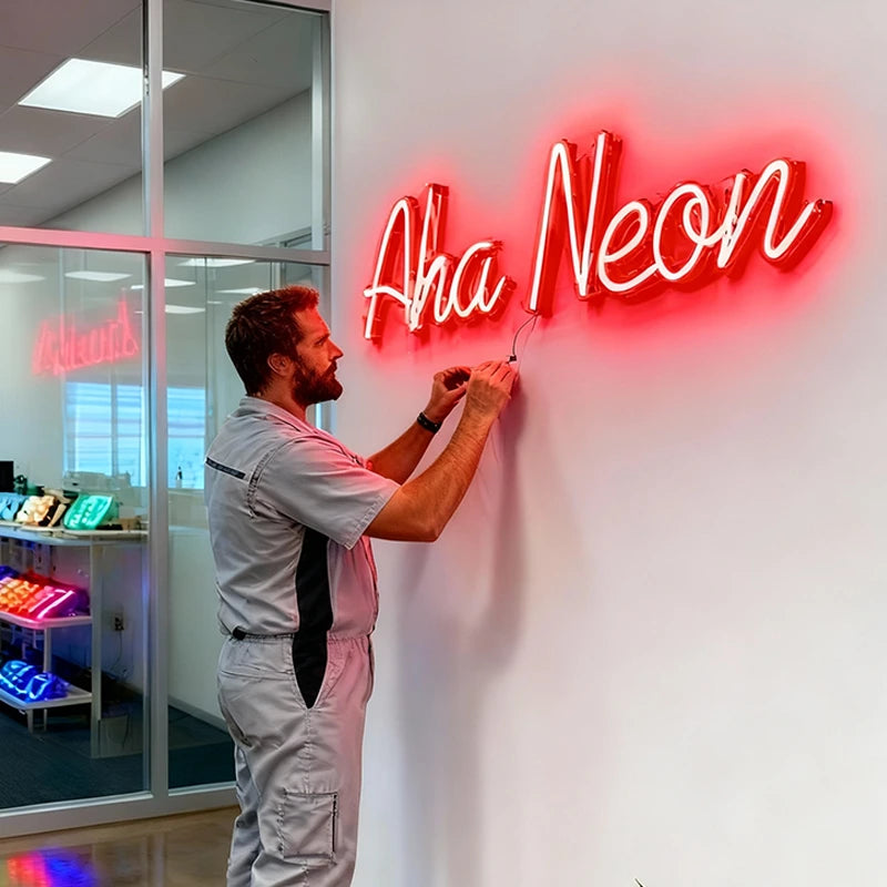 Person adjusting a neon sign on a wall with 'Aha Neon' branding.