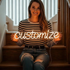 Woman holding a neon sign with the word 'customize' in a home setting.
