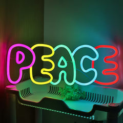 Neon sign spelling 'PEACE' in pink, yellow, green, and red on a dark background.