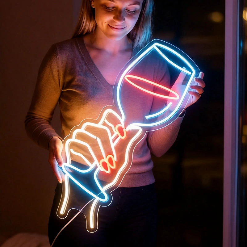Person holding a neon light sculpture of a hand holding a glass.