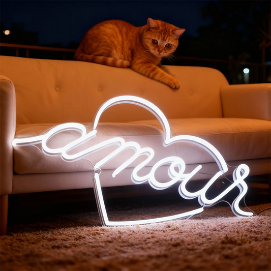 Neon sign with 'amour' in a living room setting with a cat on a couch.