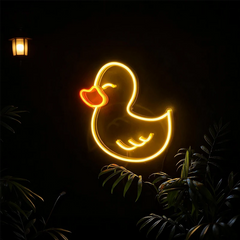Neon light shaped like a duck in a dark outdoor setting with plants.