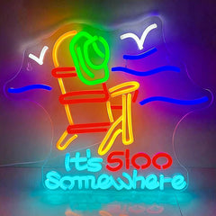 Neon sign of a beach chair with 'It's 500 Somewhere' text on a dark background