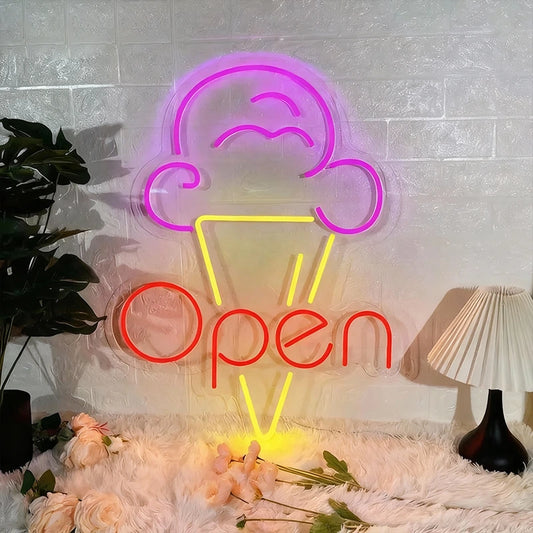 Neon sign with ice cream cone and 'Open' text on a textured wall with flowers and a lamp.