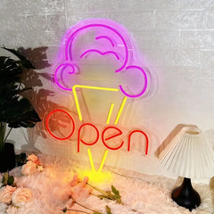 Neon sign with ice cream cone and 'Open' text on a textured wall with decorative elements.