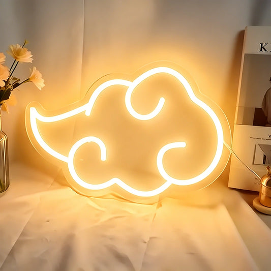 Neon cloud-shaped light on a table with books and flowers in the background