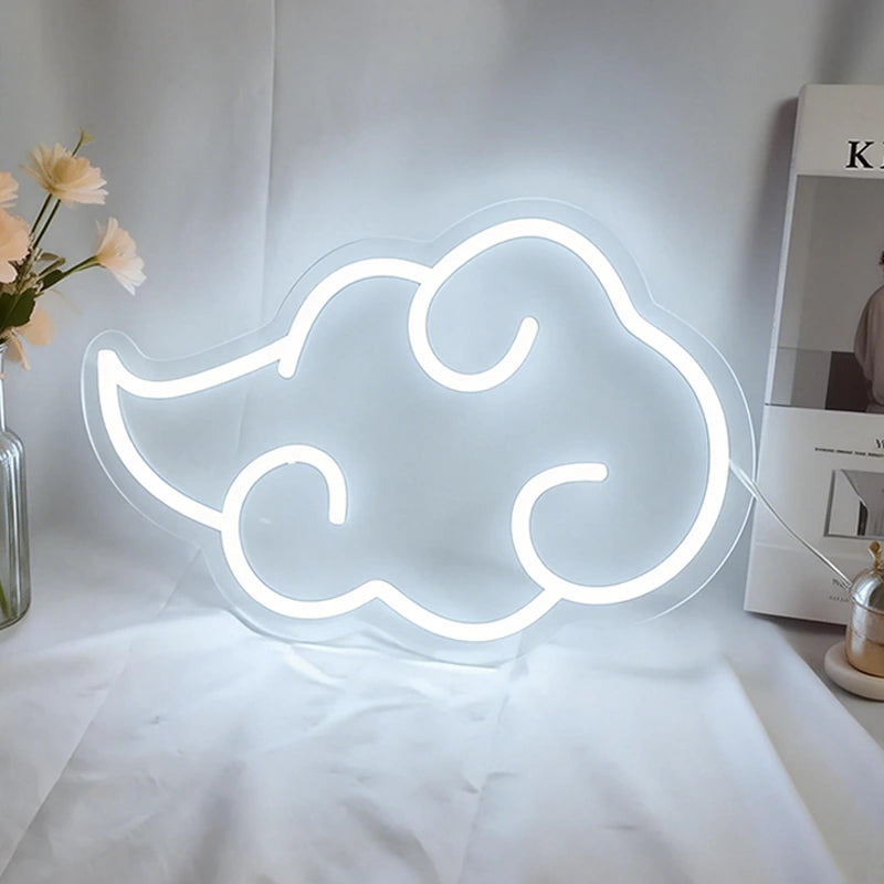 Neon cloud-shaped sign on a white surface with a vase of flowers and books in the background.