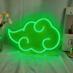 Green neon cloud-shaped sign glowing green on a white surface with a blurred background