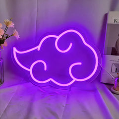 Neon cloud-shaped sign emitting a purple glow on a white surface.