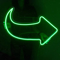 Neon green arrow-shaped light on a black background