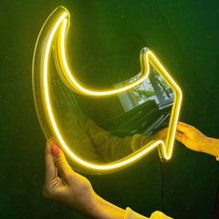 Neon arrow shape held by a hand against a dark background