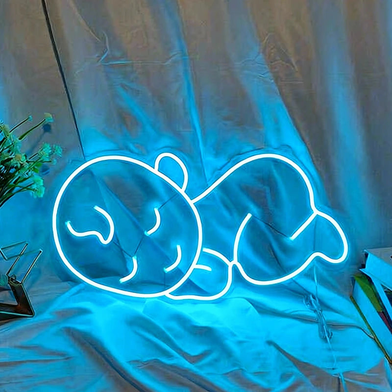 Neon sign of a baby lying down on a reflective surface with a curtain background