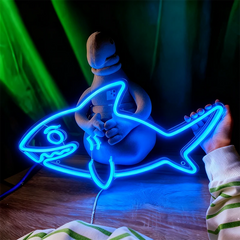Blue neon sign shaped like a fish with a person holding it, against a dark background.