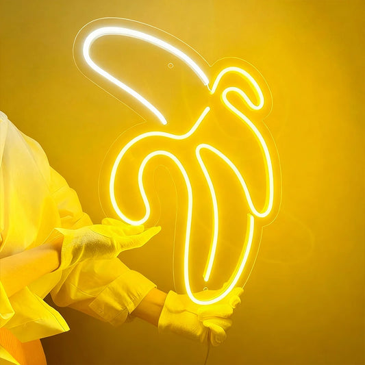 Neon banana sign held by a person wearing yellow gloves against a yellow background