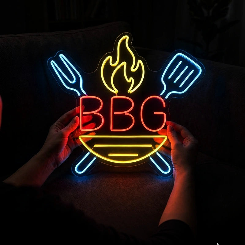 Neon sign with 'BBQ' and utensils held by hands against a dark background