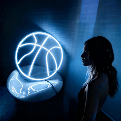 Neon light shaped like a basketball with a person standing in front of it against a dark background