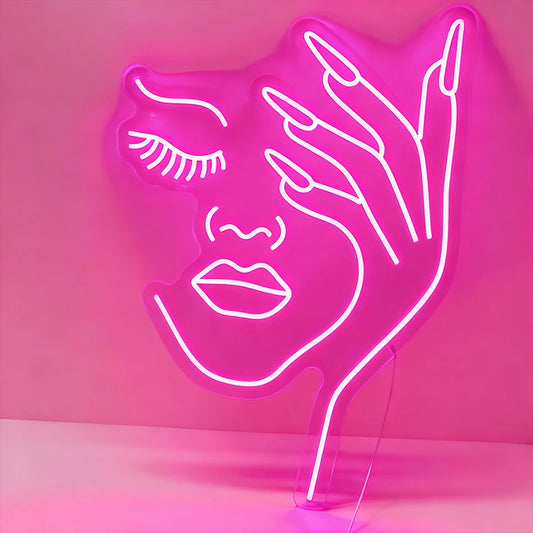 Neon light shaped like a face with a hand on a pink background