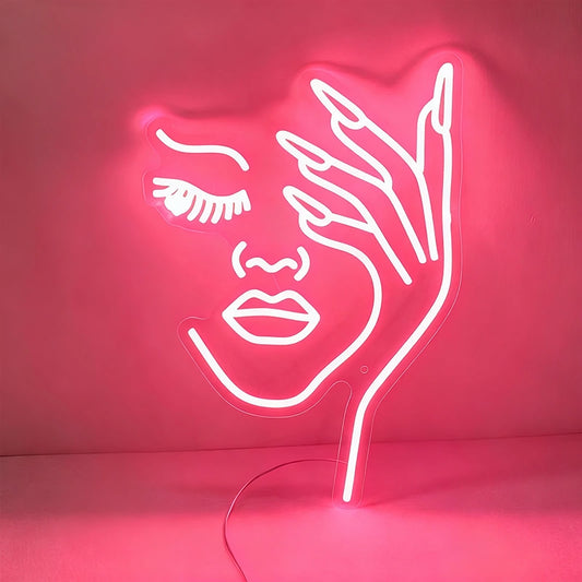 Neon sign shaped like a face with a hand on a light pink background