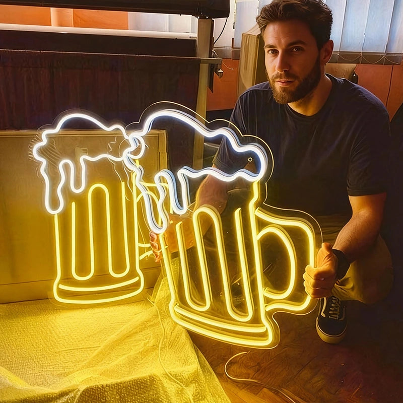 Man holding a beer mug neon sign in a casual setting.