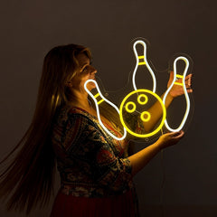 Woman looking and holding a bowling neon sign with lemon yellow and white color in a dark background