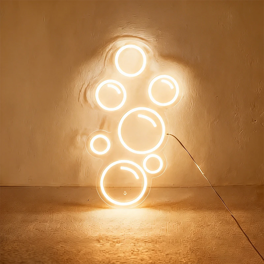 Warm white neon light shaped like bubbles on a wall.