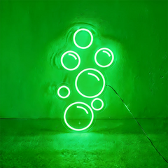 Green neon light shaped like bubbles on a wall.