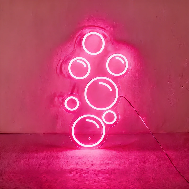Hot pink neon light shaped like bubbles on a wall.
