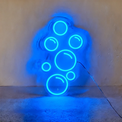 Blue neon light shaped like bubbles on a wall.