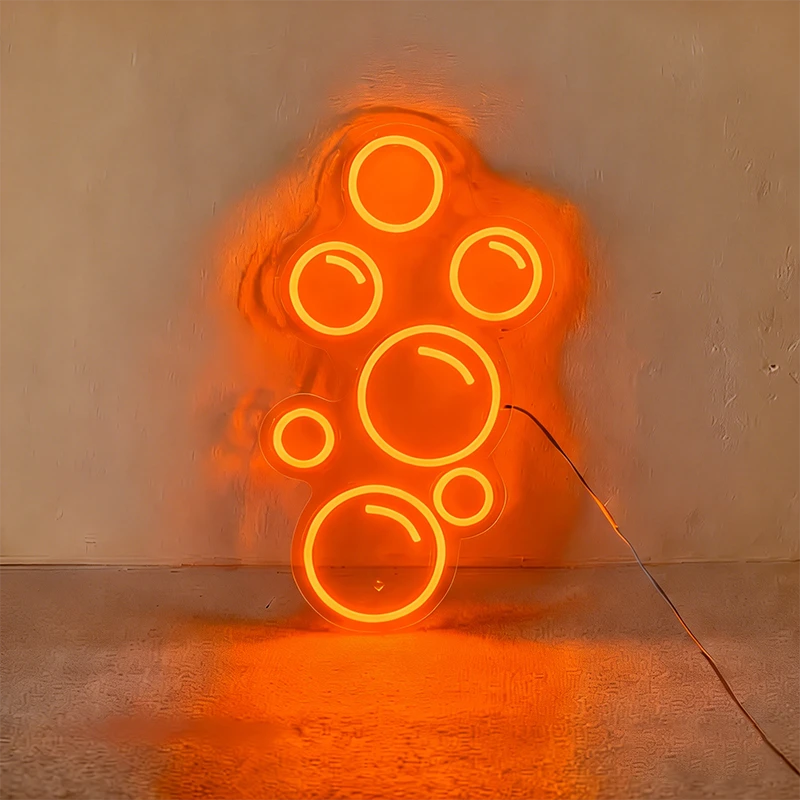 Orange neon light shaped like bubbles on a wall.