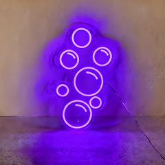 Purple neon light shaped like bubbles on a wall.