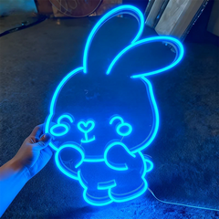 Neon light shaped like a cartoon character on a dark background