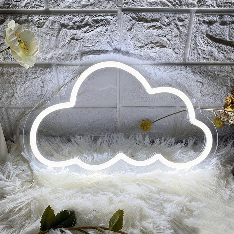 White cloud-shaped neon light on a textured surface with a flower and green leaves.