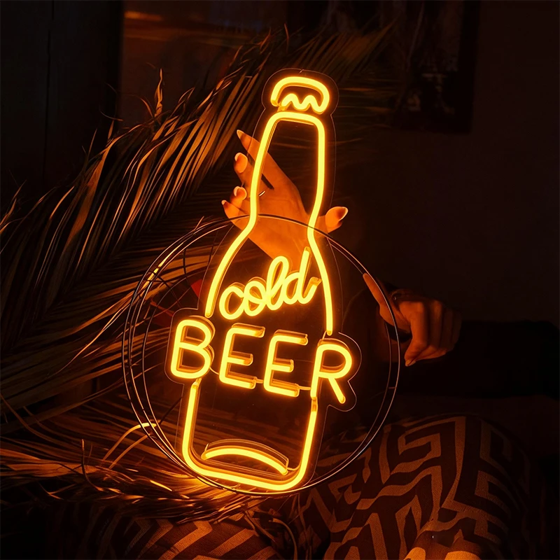 Neon sign shaped like a beer bottle with 'cold BEER' text, glowing in a dark setting.