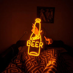 Neon sign shaped like a beer bottle with 'Cold Beer' text in a dimly lit room.