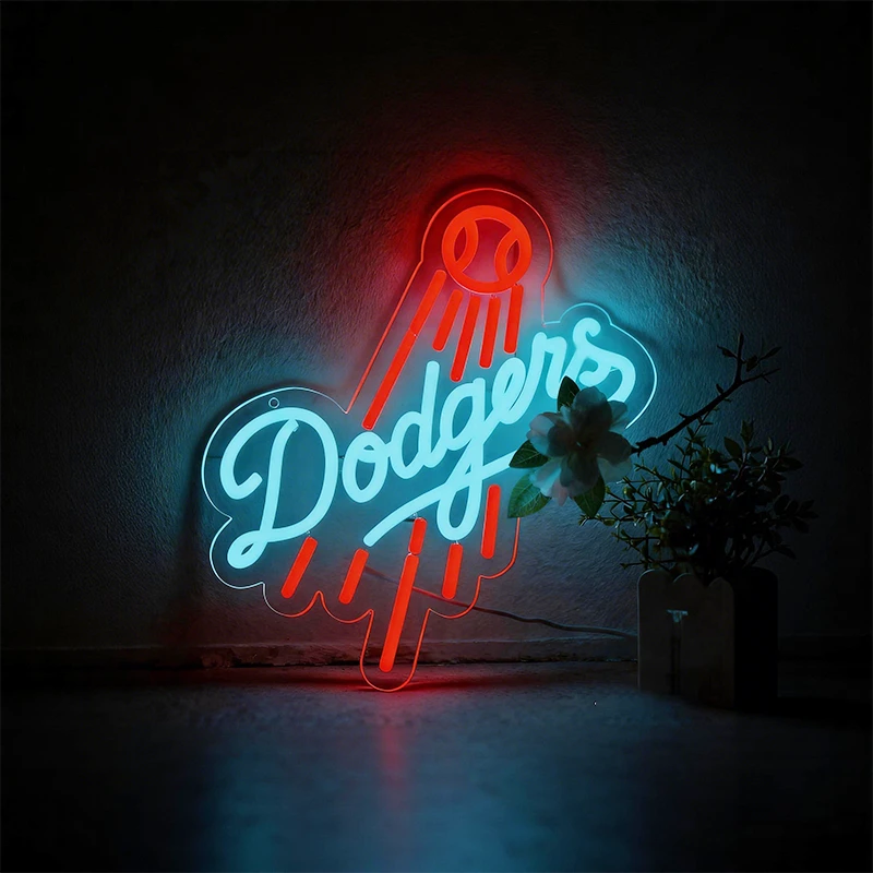 Neon sign with 'Dodgers' logo on a textured wall.