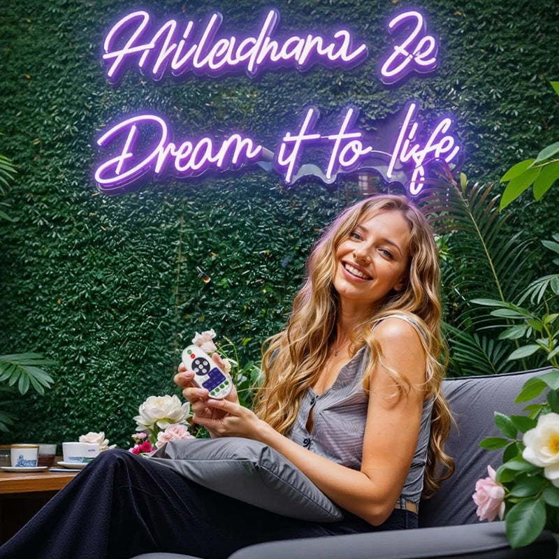 Woman sitting outdoors with a neon sign in the background