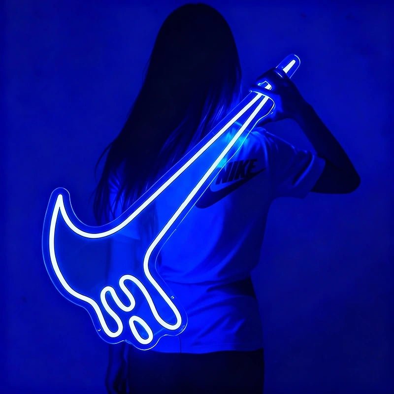 Person holding a blue neon nike-shaped light against a blue background