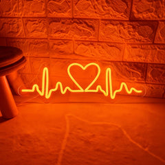 Neon with orange light shaped like a heart with an ECG line on a textured wall.